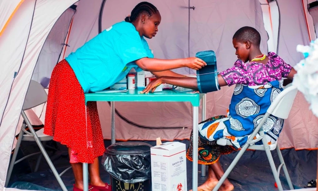 Health attendant taking check up to a patient in a tent